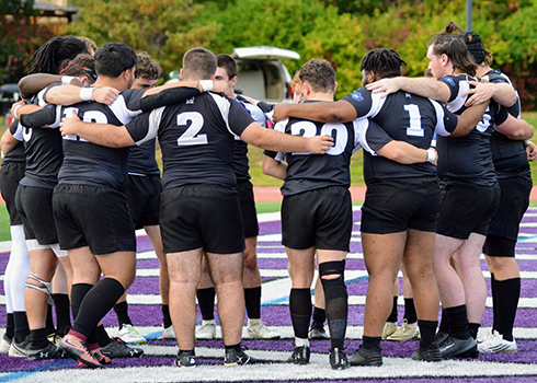 Curry College Rugby team in a huddle