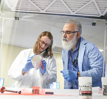 Professor Jim Jabbour observes student in Forensics class