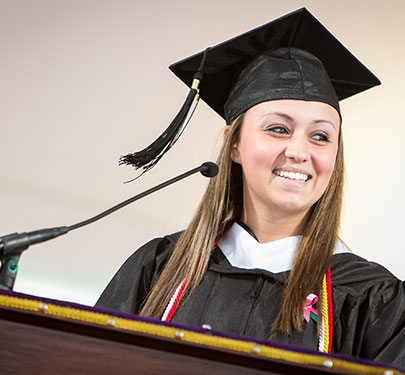 Alumna with cap and gown on
