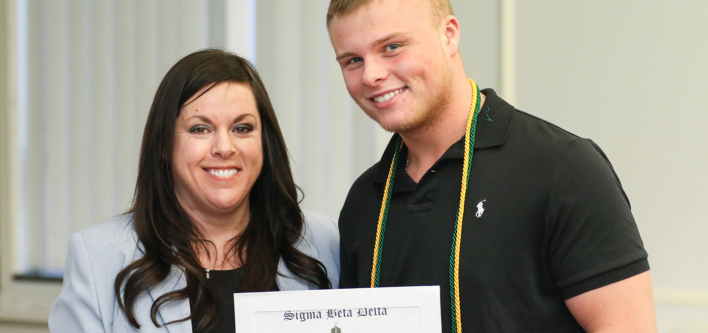 A Sigma Beta Delta member poses with faculty