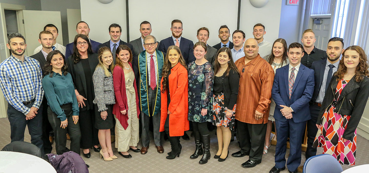 A Sigma Beta Delta member poses with faculty