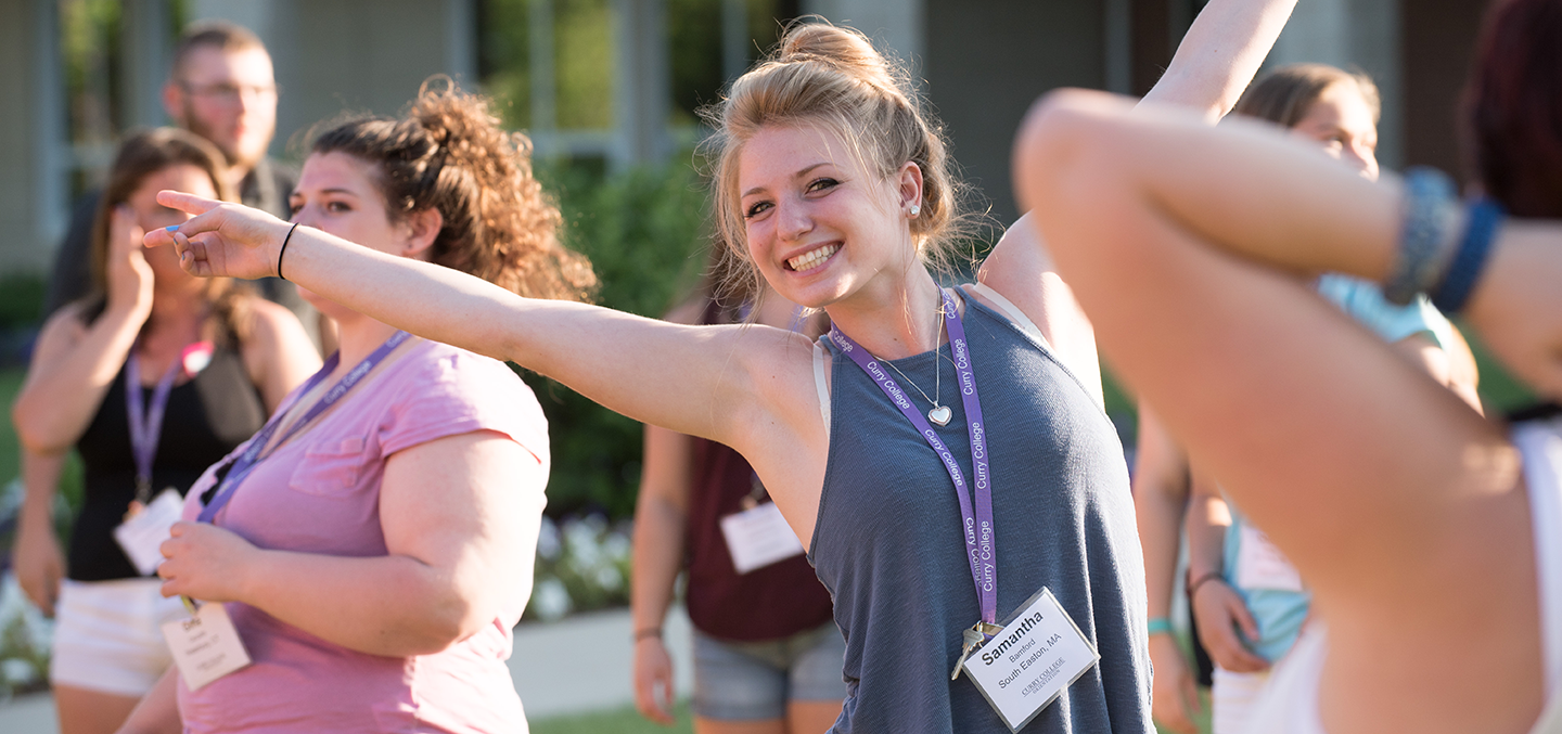 Student lifts arms with glee outside the Student Center