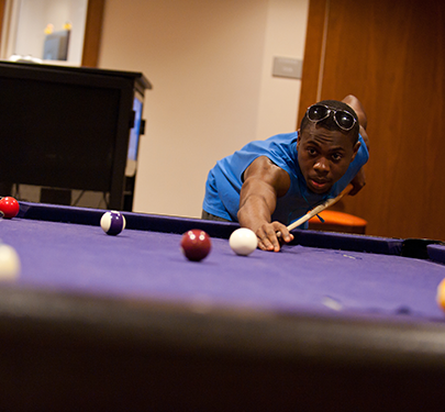 A Curry student lines up a pool shot