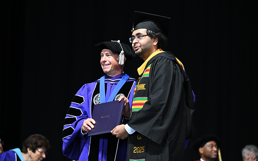 Rishabh Goenka receives his diploma from Curry College President Jay Gonzalez