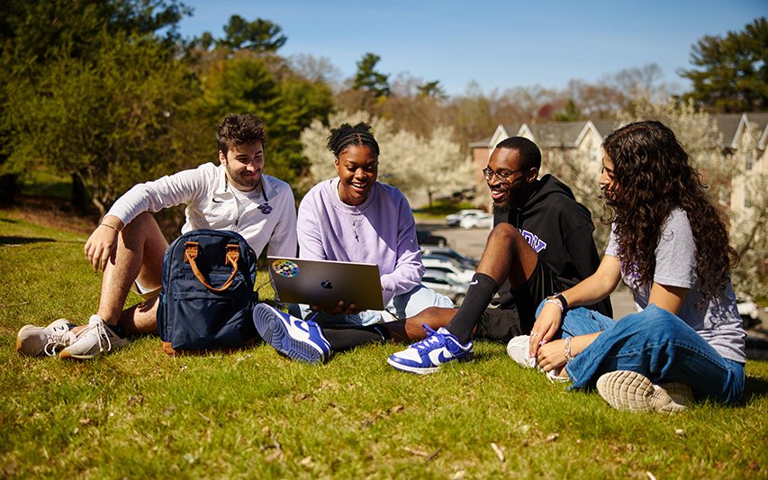 Curry College students study on a laptop on Suites Hill