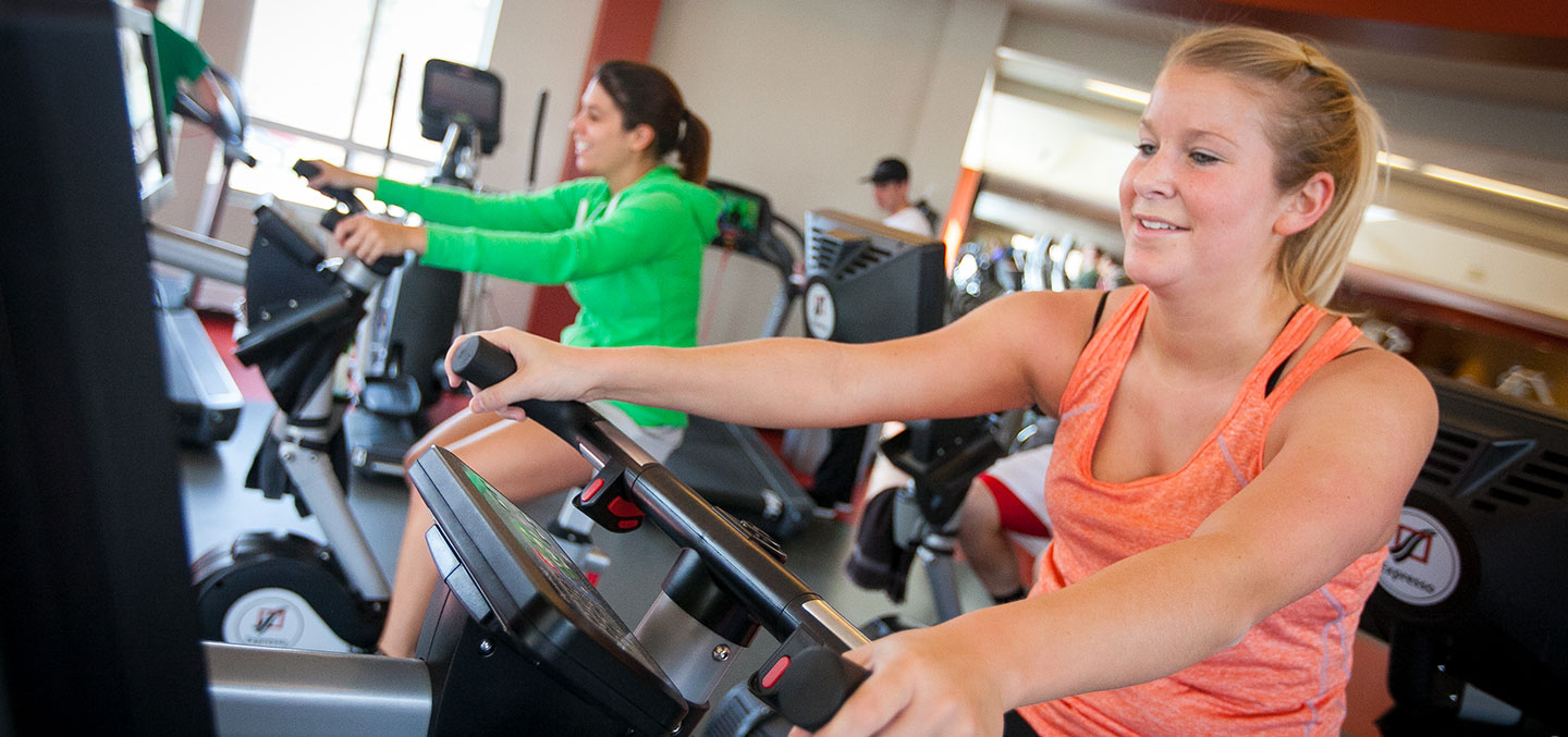 Students exercise on fitness center bikes