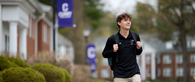 A student walks to class on the Curry College Quad