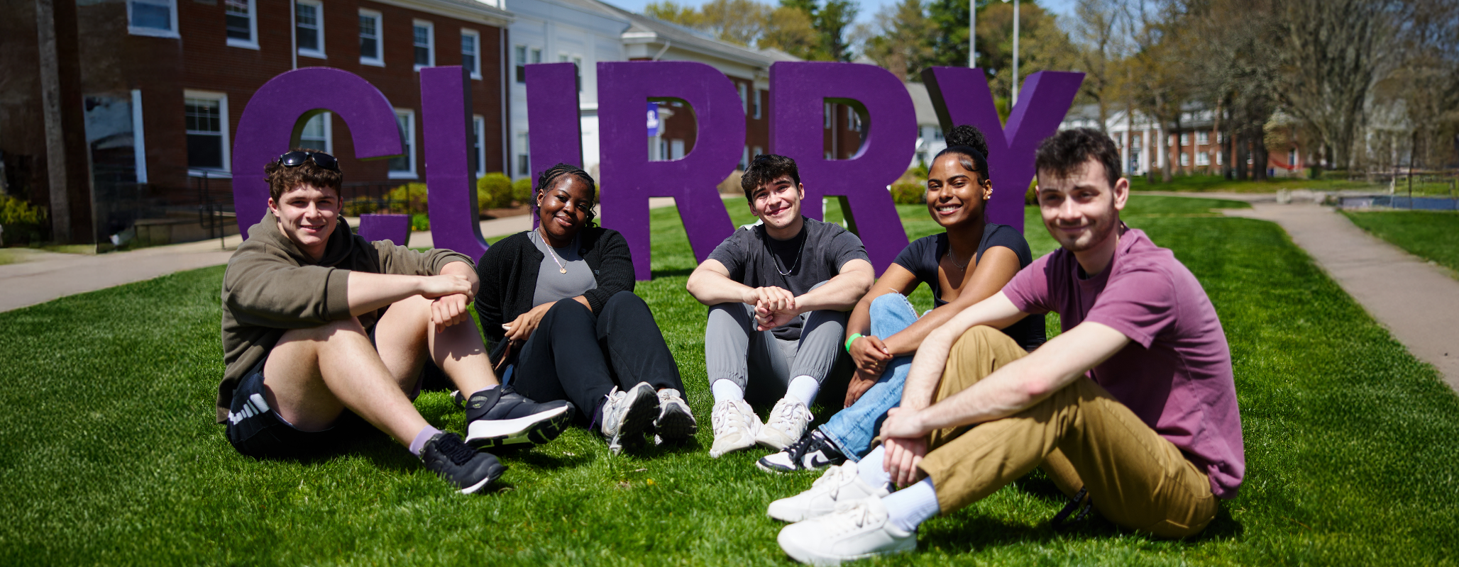 Students pose on the Quad in front of the "Curry" letters