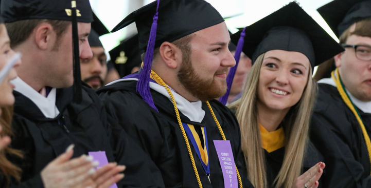 Curry College students smiling at Graduation